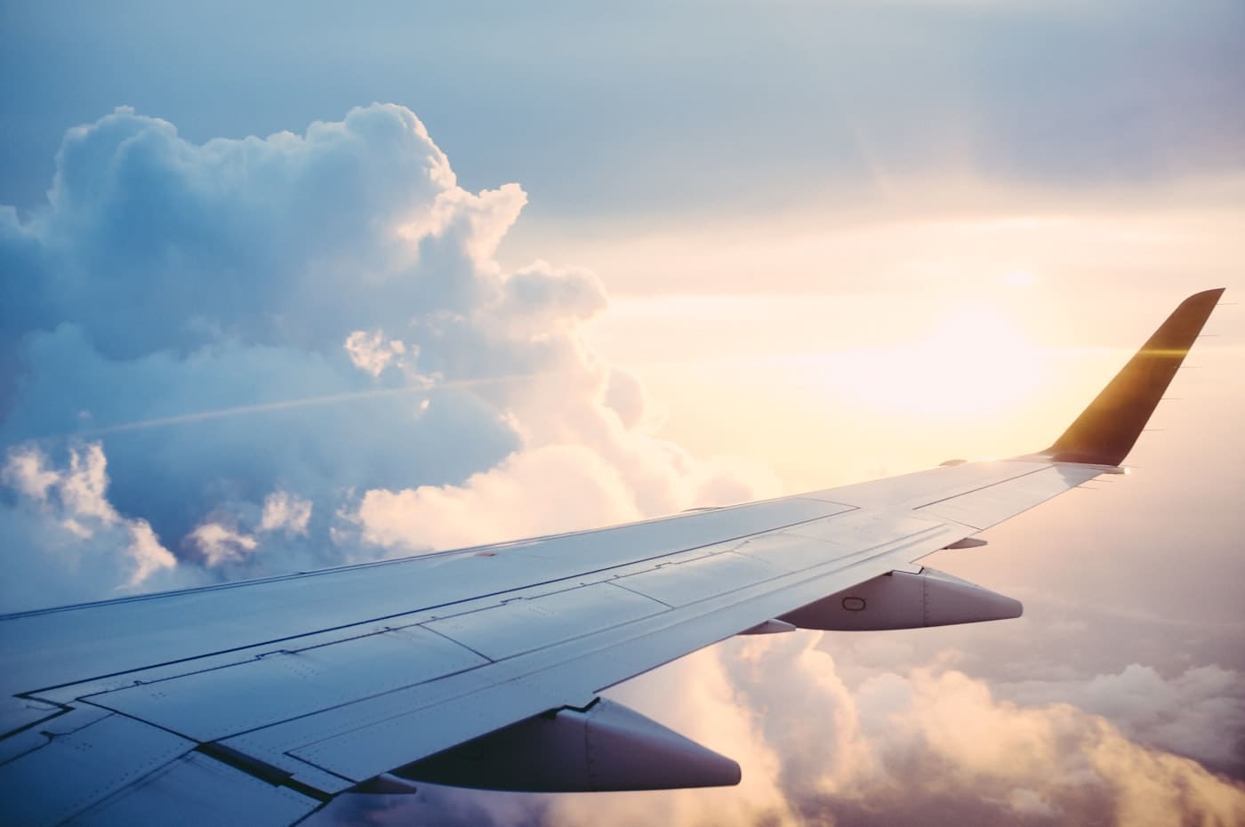 The wing of an aircraft above the clouds at sunrise